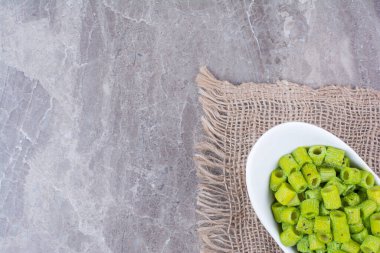 Soslu yeşil makarna ve beyaz seramik tabakta bitkiler. Yüksek kalite fotoğraf