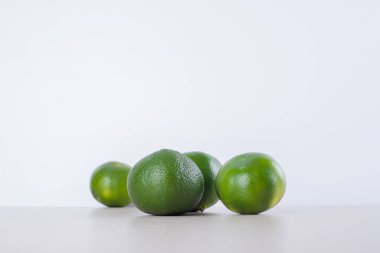 Mermer zemin üzerinde bir sürü yeşil mandalina var. Yüksek kalite fotoğraf