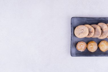 Siyah bir tabakta kuru incir ve kiraz. Yüksek kalite fotoğraf