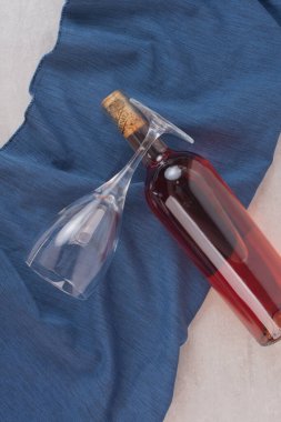 Mavi masa örtüsünün üzerinde bir şişe gül şarabı ve bardak. Yüksek kalite fotoğraf