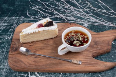 Tahta tahtada kremalı pasta ve bir fincan çay. Yüksek kalite fotoğraf