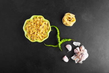 Siyah arkaplanlı çiğ makarna, malzemelerle, üst manzara. Yüksek kalite fotoğraf
