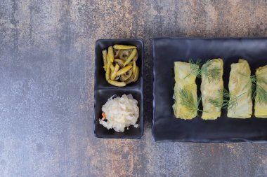 Lahana dolma turşulu siyah tabakta yuvarlanıyor. Yüksek kalite fotoğraf