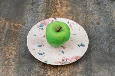 Mermer zemin üzerinde güzel bir tabakta soyulmuş yeşil elma. Yüksek kalite fotoğraf