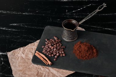 Esrar ve pudralı siyah arkaplanda kahve çekirdekleri. Yüksek kalite fotoğraf