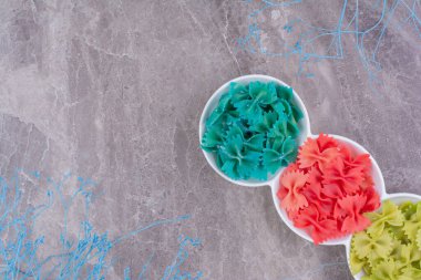 Üç beyaz fincanda mavi, kırmızı ve yeşil hamur makarnaları. Yüksek kalite fotoğraf