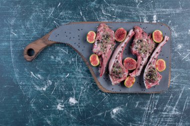 Tahtada çiğ pirzola, incir ve kurutulmuş otlarla. Yüksek kalite fotoğraf