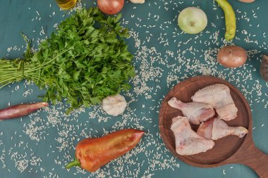 Tahta bir tahtanın üzerinde baharat ve sebzeli çiğ tavuk parçaları. Yüksek kalite fotoğraf