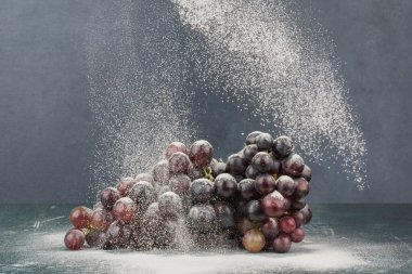 Mermer masa üzerinde toz ile süslenmiş siyah üzümler. Yüksek kalite fotoğraf