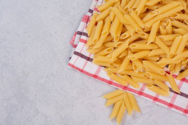 Çizgili masa örtüsünde pişmemiş sarı makarna. Yüksek kalite fotoğraf