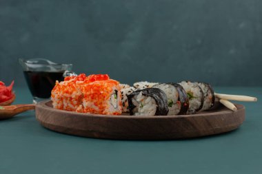 Mavi arka planda zencefil turşusu ve soya soslu suşi rulosu. Yüksek kalite fotoğraf