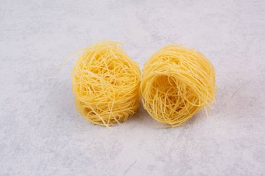 Mermer zemin üzerinde pişmemiş spagetti yuvaları. Yüksek kalite fotoğraf