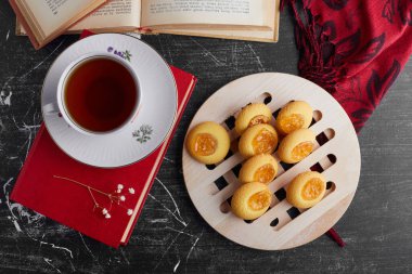 Portakal reçelli kurabiyeler bir fincan çayla servis edilir, üst manzara. Yüksek kalite fotoğraf