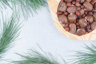 Tahta tabakta kestane ve kurumuş gül kalçası. Yüksek kalite fotoğraf