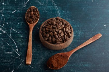 Kahve çekirdekleri ve tahta kaşıklarda toz. Yüksek kalite fotoğraf