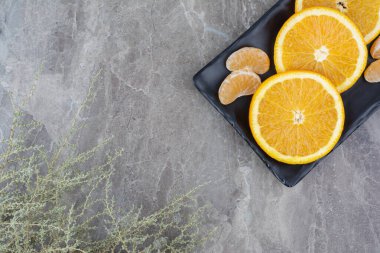 Siyah tabakta portakal ve mandalina dilimleri. Yüksek kalite fotoğraf