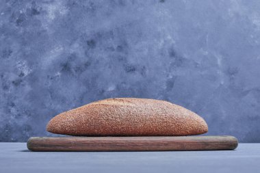 Ahşap bir tahtada gri arka planda el yapımı oval ekmek. Yüksek kalite fotoğraf