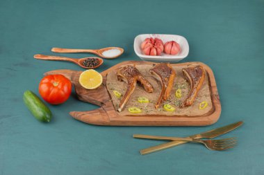 Mavi yüzeyde sebzeli ızgara kuzu pirzolası. Yüksek kalite fotoğraf