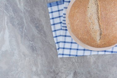 Masa örtüsünün üzerinde bir somun taze kahverengi ekmek. Yüksek kalite fotoğraf