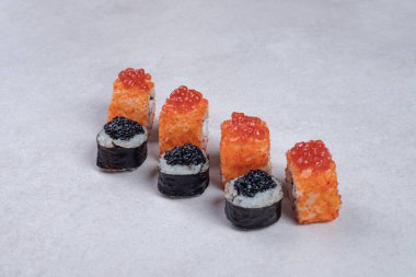 Maki ve California suşisi beyaz arka planda yuvarlanıyor. Yüksek kalite fotoğraf