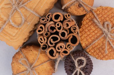 Beyaz arka planda tarçın çubukları olan ipteki kurabiyeler. Yüksek kalite fotoğraf