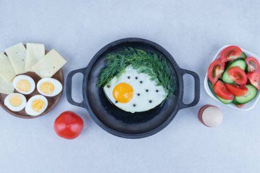 Omletli tava ve haşlanmış yumurta, peynir, domates beyaz arka planda.