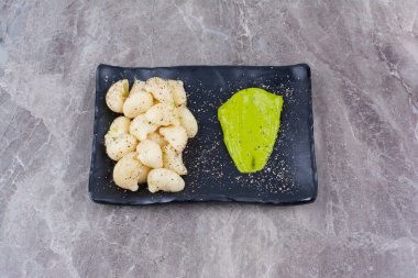 Baharatlı makarna ve yeşil pesto ya da siyah tabakta moka sosu. Yüksek kalite fotoğraf