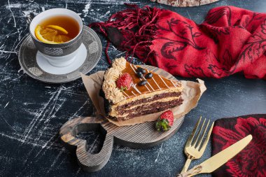 Bir dilim çikolatalı karamelli kek ve bir fincan çay. Yüksek kalite fotoğraf