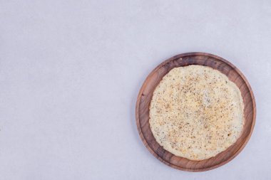 Beyaz arka planda ahşap tabakta lezzetli bir pizza.