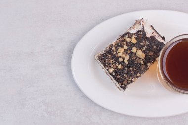 Beyaz tabakta bir dilim kek ve bir fincan çay. Yüksek kalite fotoğraf