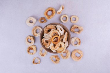 Gri arka planda tahta bir fincanda kurumuş elma dilimleri. Yüksek kalite fotoğraf