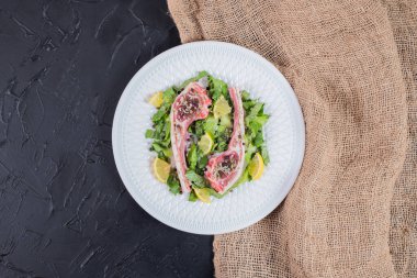 Limon dilimleri ve yeşil ile beyaz tabakta iki pirzola. Yüksek kalite fotoğraf