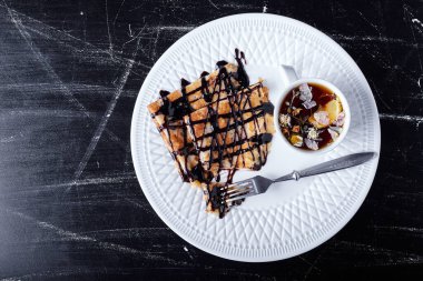 Beyaz tabakta krep, çikolata şurubu ve çay. Yüksek kalite fotoğraf