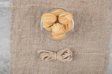 Çuval bezinde cam kasede ceviz şeklinde kurabiyeler. Yüksek kalite fotoğraf