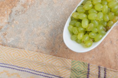 Mermer zemin üzerinde beyaz kasede taze üzümler. Yüksek kalite fotoğraf