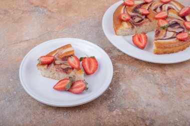 Etrafında meyveler olan beyaz bir tabakta çilekli turta. Yüksek kalite fotoğraf