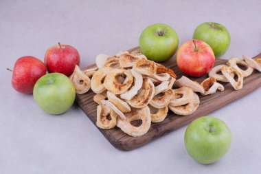 Gri arka planda tahta bir tahtada taze elmalı kuru elma dilimleri. Yüksek kalite fotoğraf