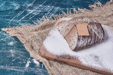 Mavi arka planda etiketli siyah ekmek. Yüksek kalite fotoğraf