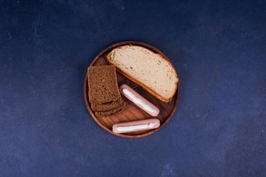 Siyah arka planda beyaz, siyah ekmek ve sosis tabağı. Yüksek kalite fotoğraf