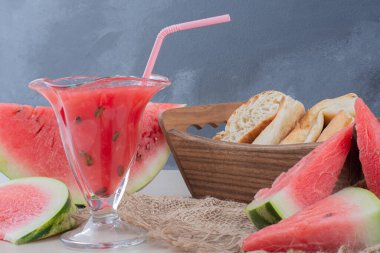 Bir bardak karpuz püresi ve beyaz masada bir sepet ekmek. Yüksek kalite fotoğraf