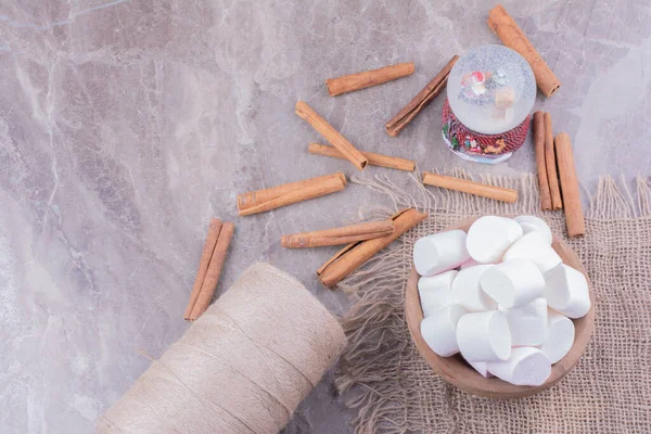 Tahta bir fincanda beyaz şekerlemeler ve etrafında tarçın çubukları. Yüksek kalite fotoğraf