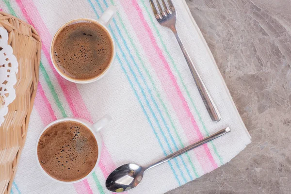 Masa örtüsünün üzerinde çatal bıçak takımı olan iki fincan kahve. Yüksek kalite fotoğraf
