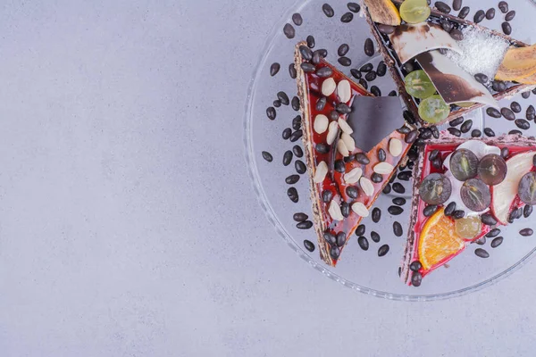 Çikolata, fındık ve meyveli cam tabakta üçgen şeklinde pasta dilimleri. Yüksek kalite fotoğraf