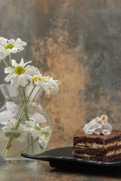 Mermer arka planda papatya çiçekli bir parça çikolatalı pasta. Yüksek kalite fotoğraf
