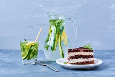 Beyaz tabakta bir dilim çikolatalı kek ve mojito kokteyli. Yüksek kalite fotoğraf