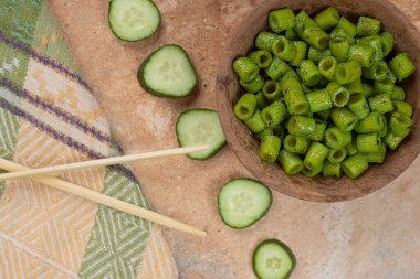 Turuncu arka planda salatalık dilimli yeşil makarna. Yüksek kalite fotoğraf