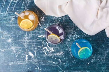 Mavi arka planda üç renkli bardaklar. Yüksek kalite fotoğraf