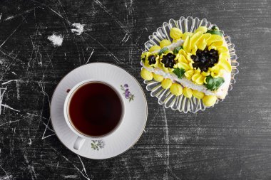Ayçiçeği süslemeli bir dilim pasta ve bir fincan çay. Yüksek kalite fotoğraf