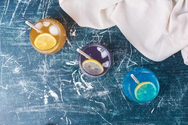 Mavi arka planda üç renkli bardaklar. Yüksek kalite fotoğraf