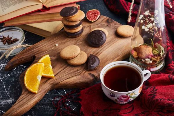 Çikolatalı sünger kurabiyesi ve bir fincan çay ve portakal dilimleri. Yüksek kalite fotoğraf